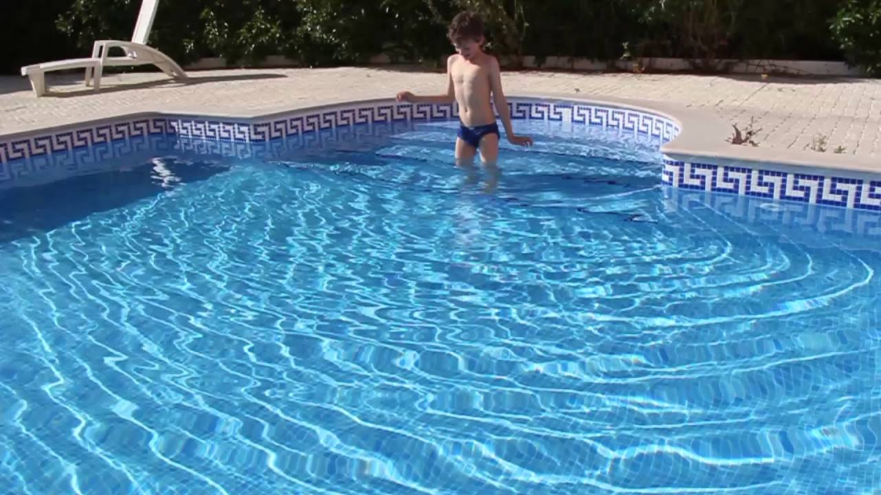 young boy standing in pool